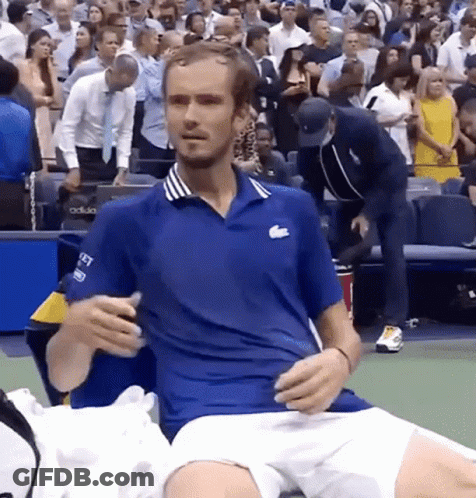 Man In Blue Lacoste Shirt Sitting On Tennis Court GIF