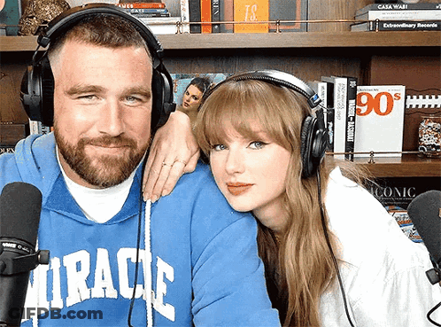 Man In Blue Miracle Sweatshirt With Woman Wearing Headphones And Microphone GIF