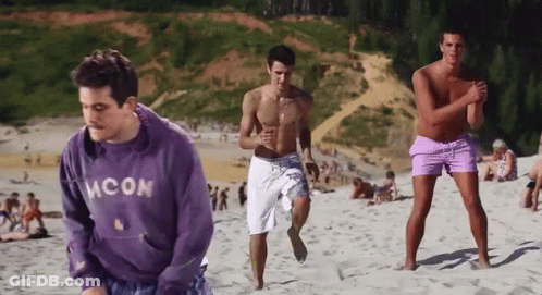 Man In Blue Moon Sweatshirt On City Street At Night GIF