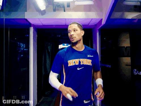 Man In Blue New York Shirt Walking Through Purple Doorway GIF