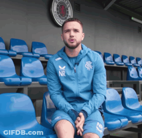 Man In Blue NR Jacket Sitting In Blue Chairs GIF