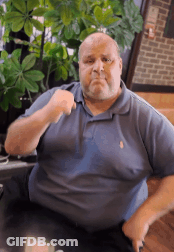 Man In Blue Polo Shirt With Fist Up GIF