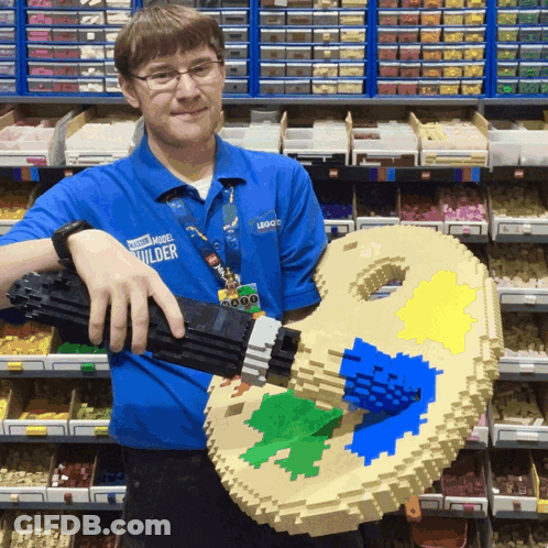 Man In Blue Power Model Builder Shirt Holding Lego Palette GIF