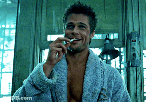Man In Blue Robe Brushing Teeth And Smoking Cigarette GIF