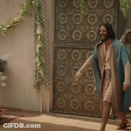 Man In Blue Robe In Front Of Wrought Iron Door GIF