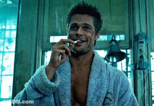 Man In Blue Robe Smoking Cigarette And Smiling GIF