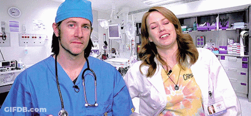 Man In Blue Scrub And Woman In White Lab Coat GIF