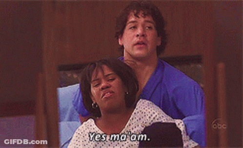 Man In Blue Scrub Holding Woman In Hospital Gown Saying Yes Ma'am GIF