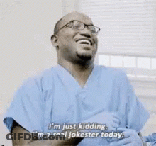 Man In Blue Scrubs Laughing Saying I'm Just Kidding GIF