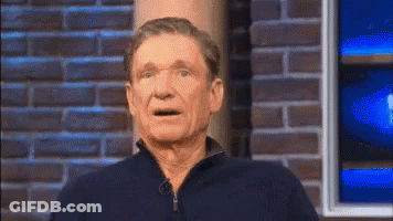 Man In Blue Shirt Against Brick Wall GIF
