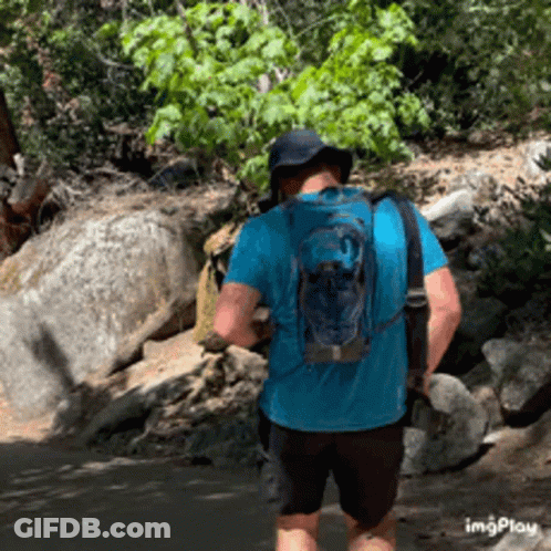 Man In Blue Shirt And Backpack Walking Trail GIF