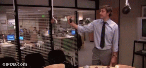 Man In Blue Shirt And Black Tie By Window With Blinds GIF