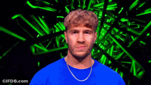 Man In Blue Shirt And Chain Looking At Camera GIF