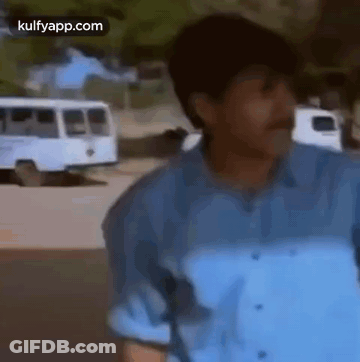 Man In Blue Shirt And Mustache Standing In Front Of Bus GIF