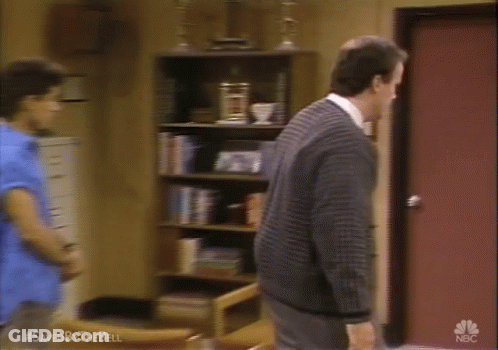 Man In Blue Shirt And Red Tank Top Beside Man In Suit GIF