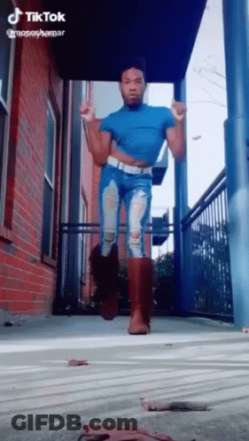 Man In Blue Shirt And Ripped Jeans Dancing GIF