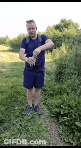 Man In Blue Shirt And Shorts Holding Soda GIF