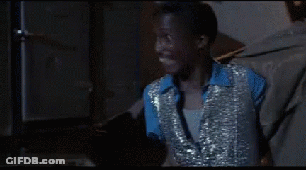 Man In Blue Shirt And Silver Vest Smiles GIF