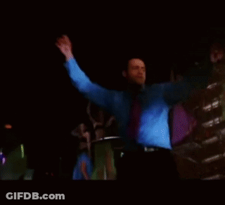 Man In Blue Shirt And Tie Dancing In Dark Room GIF