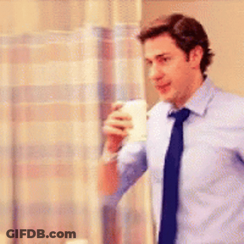 Man In Blue Shirt And Tie Holding Coffee In Hospital GIF