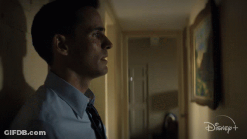 Man In Blue Shirt And Tie In Hallway With Disney Logo GIF