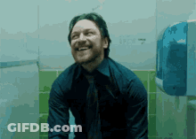 Man In Blue Shirt And Tie Sitting On Toilet Smiling GIF