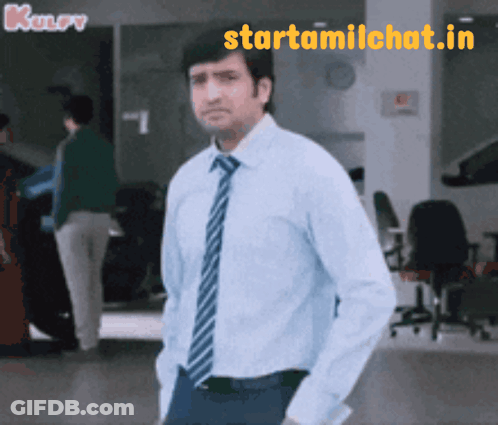 Man In Blue Shirt And Tie Standing In Front Of Starttamilchat.in Sign GIF
