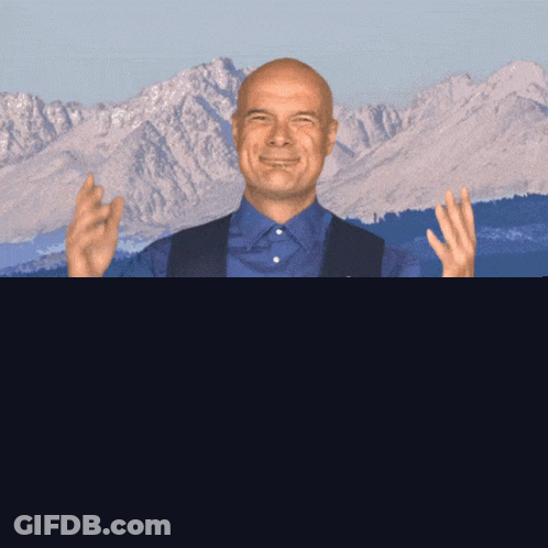 Man In Blue Shirt And Vest In Front Of Mountain GIF