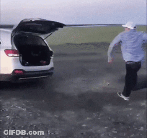 Man In Blue Shirt And White Hat Running To Car With Open Trunk GIF