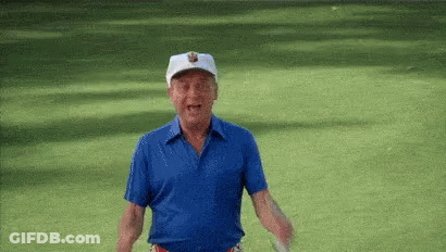 Man In Blue Shirt And White Hat Standing On Green Field GIF