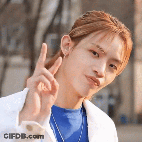 Man In Blue Shirt And White Jacket Making Peace Sign GIF