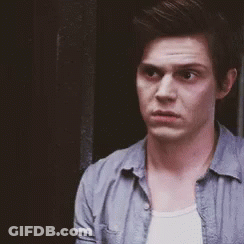 Man In Blue Shirt And White Tank Top Standing In Front Of Door GIF