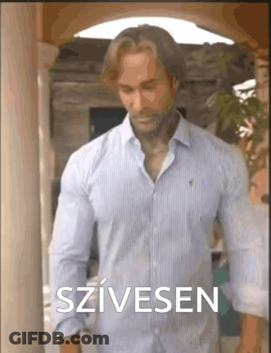 Man In Blue Shirt At Building With Szivesen GIF