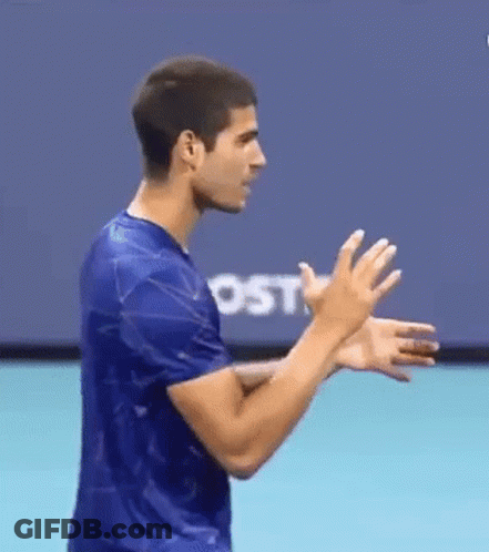 Man In Blue Shirt Clapping In Front Of Screen GIF