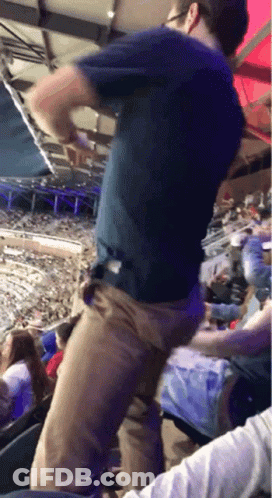 Man In Blue Shirt Dancing In Crowded Stadium GIF
