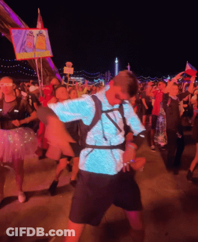 Man In Blue Shirt Dancing In Front Of I Love You Sign GIF