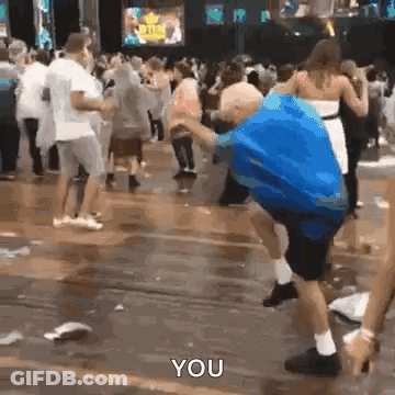 Man In Blue Shirt Dancing In Rain With Crowd GIF
