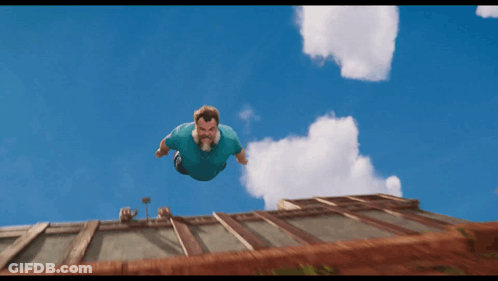 Man In Blue Shirt Flying Above Building GIF