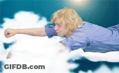 Man In Blue Shirt Flying With Arm Outstretched GIF
