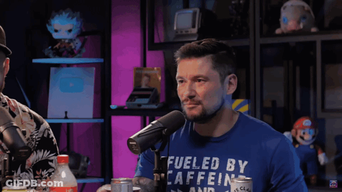 Man In Blue Shirt Fueled By Caffeine Talks Into Microphone GIF