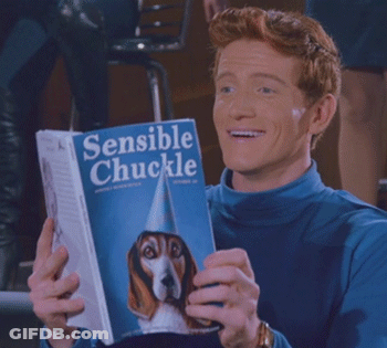 Man In Blue Shirt Holding Book Sensible Chuckle GIF