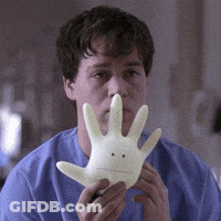 Man In Blue Shirt Holding Glove With Face GIF