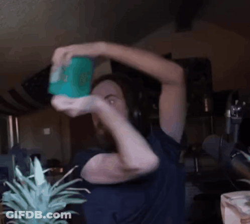 Man In Blue Shirt Holding Green Container With Cartoon Character GIF