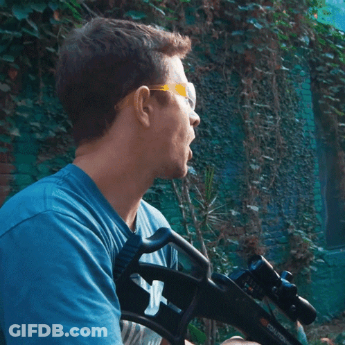Man In Blue Shirt Holding Gun GIF