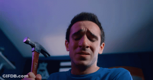 Man In Blue Shirt Holding Hammer GIF