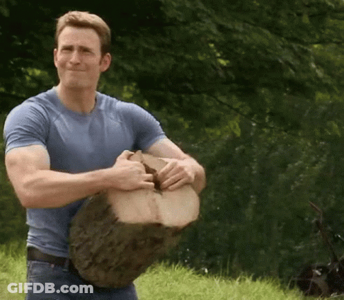 Man In Blue Shirt Holding Large Piece Of Wood GIF
