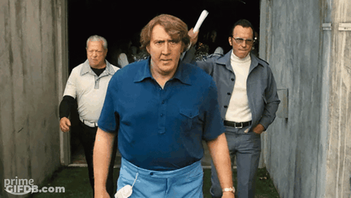 Man In Blue Shirt Holding Paper In Front Of Prime Sign GIF