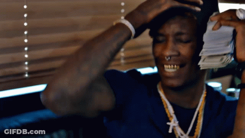 Man In Blue Shirt Holding Pile Of Money GIF