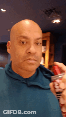 Man In Blue Shirt Holding Shaving Cream Spray Bottle GIF