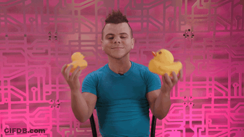 Man In Blue Shirt Holding Two Yellow Rubber Ducks GIF